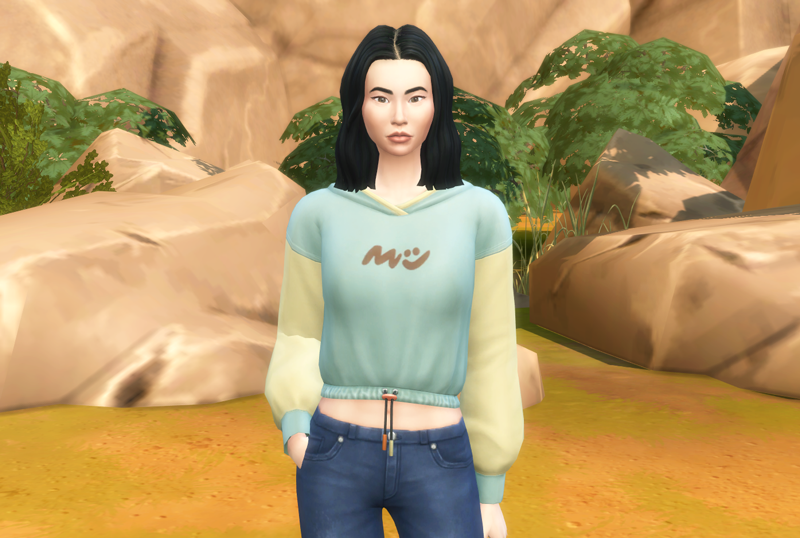 Mulan Sim, with green and yellow top in a casual pose.